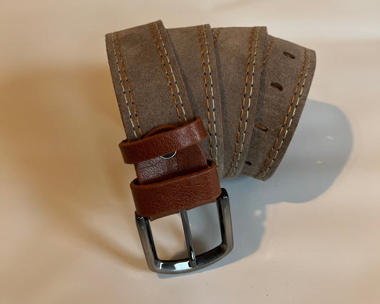 Brown leather belt with a silver buckle on a mannequin arm against a beige background